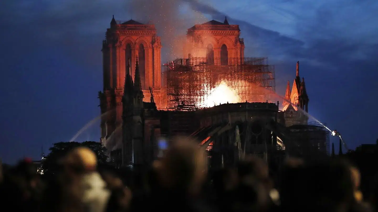 Parisianere så hjælpeløst til, da branden åd store dele af den ikoniske franske katedral.