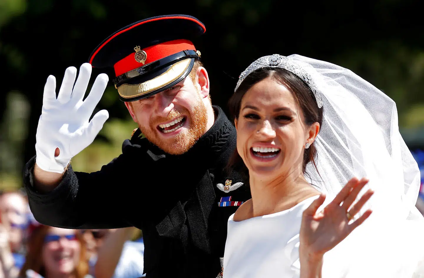 FILE PHOTO: Britain's Prince Harry and his wife Meghan wave as they ride a horse-drawn carriage after their wedding ceremony at St George's Chapel in Windsor Castle in Windsor, Britain, May 19, 2018. REUTERS/Damir Sagolj/File Photo