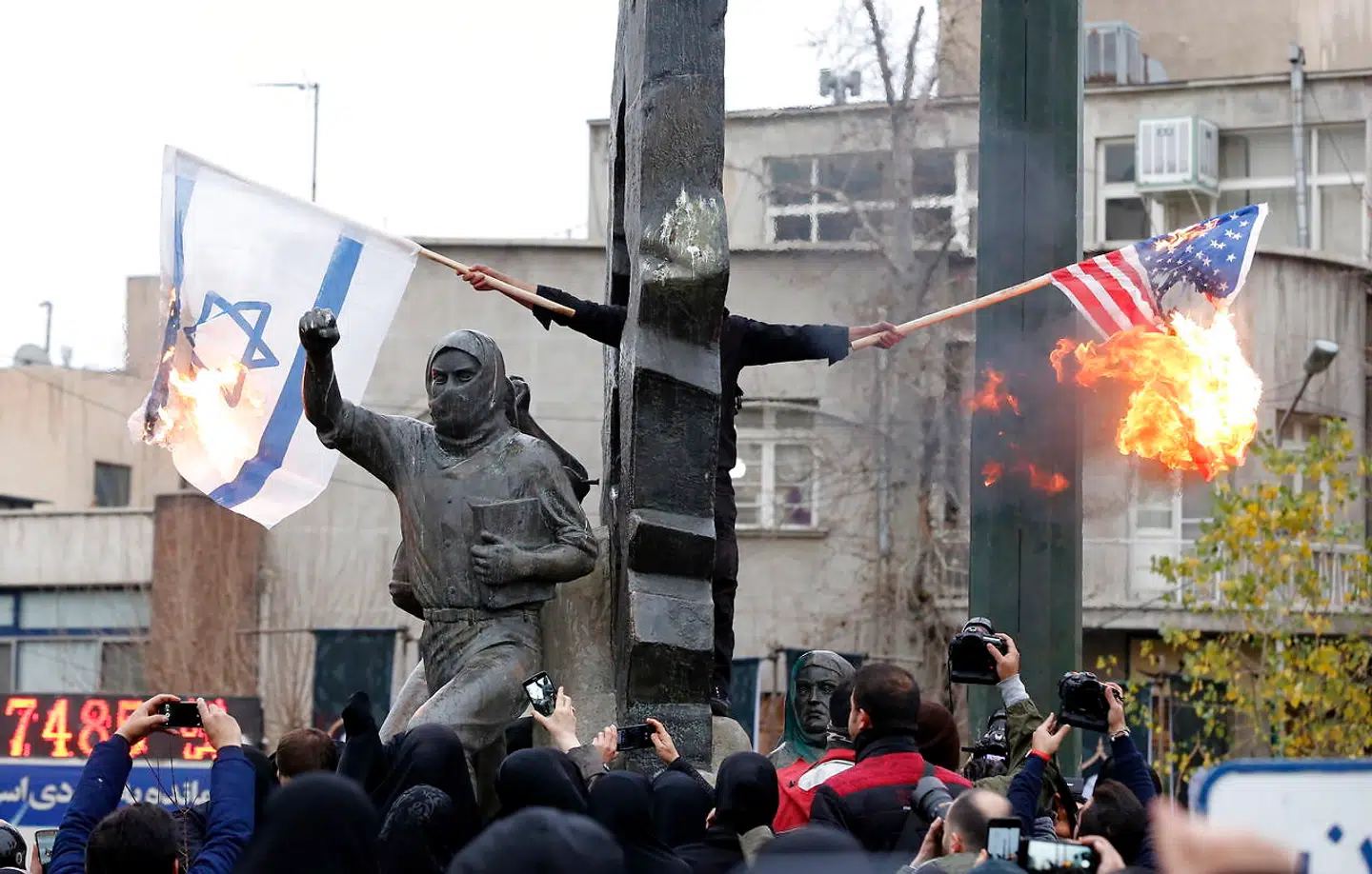 Iranere brænder amerikanske og israelske flag i Tehran.