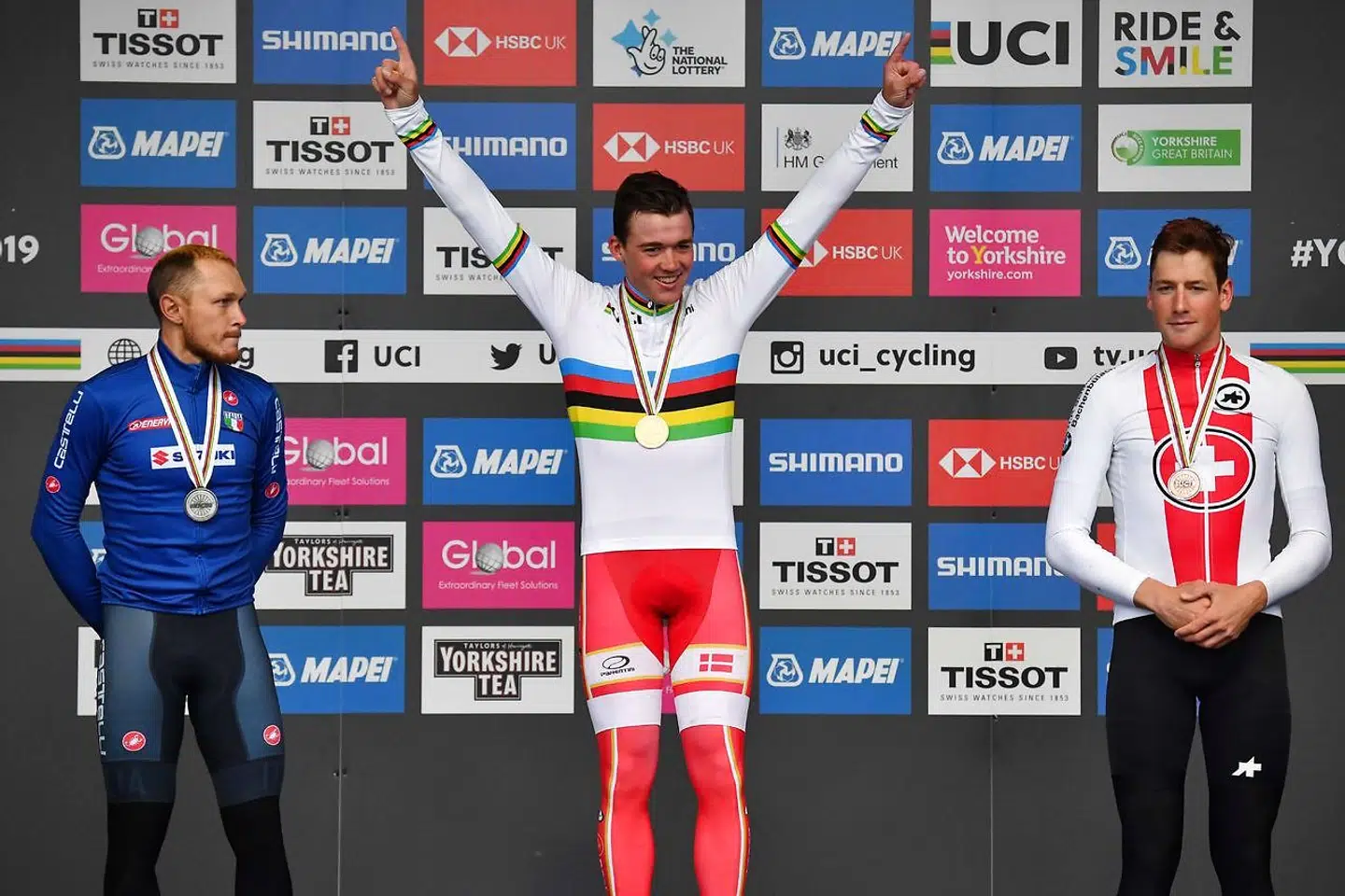 Mads Pedersen bliver hædret på podiet i Harrogate foran italienske Matteo Trentin (tv.) og schweiziske Stefan Küng (th.).