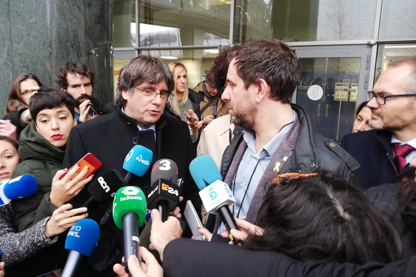Den tidligere catalanske regionspræsident Carles Puigdemont (midten t.v.) og Cataloniens tidligere sundhedsminister Toni Comin (midten t.h.) udtaler sig, den dag de begge fik udleveret deres ID-kort som akkrediterede medlemmer af EU-Parlamentet den 20. december. Det skete, efter at EU-Domstolen havde afgjort, at Spanien ikke kunne blokere for, at Puigdemont og Comin indtog de pladser, de er valgt til. Anne-Laure Mondesert/Ritzau Scanpix