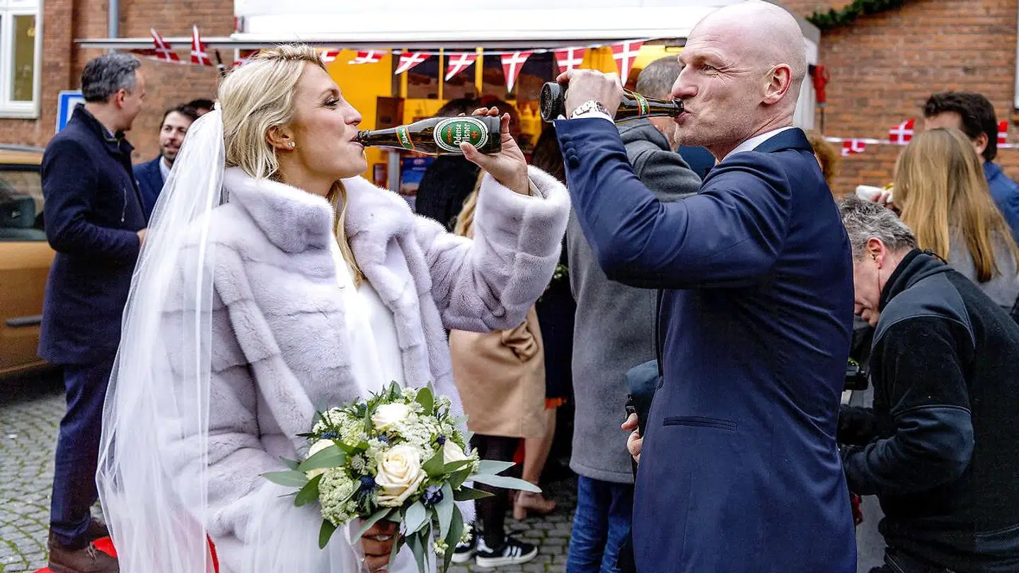 To verdener mødes med brudebuket i den ene hånd og en Albani pilsner i den anden. Brudeparret Josefine Høgh og Lasse Sjørslev får sig lige en håndbajer foran pølsevognen. Der var generelt en meget løssluppen stemning blandt gæsterne og brudeparret efter, at alt det formelle var klaret inde i kirken.