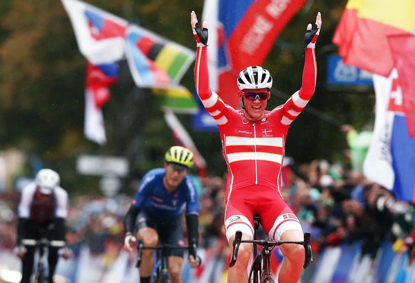 epa07880012 Mads Pedersen of Denmark celebrates winning the Elite Men's Road Race during the UCI Road Cycling World championships in Harrogate, Britain. 29 September 2019. Matteo Trentin (C) of Italy placed second and Stefan Kung (rear) of Switzerland third. EPA/NIGEL RODDIS