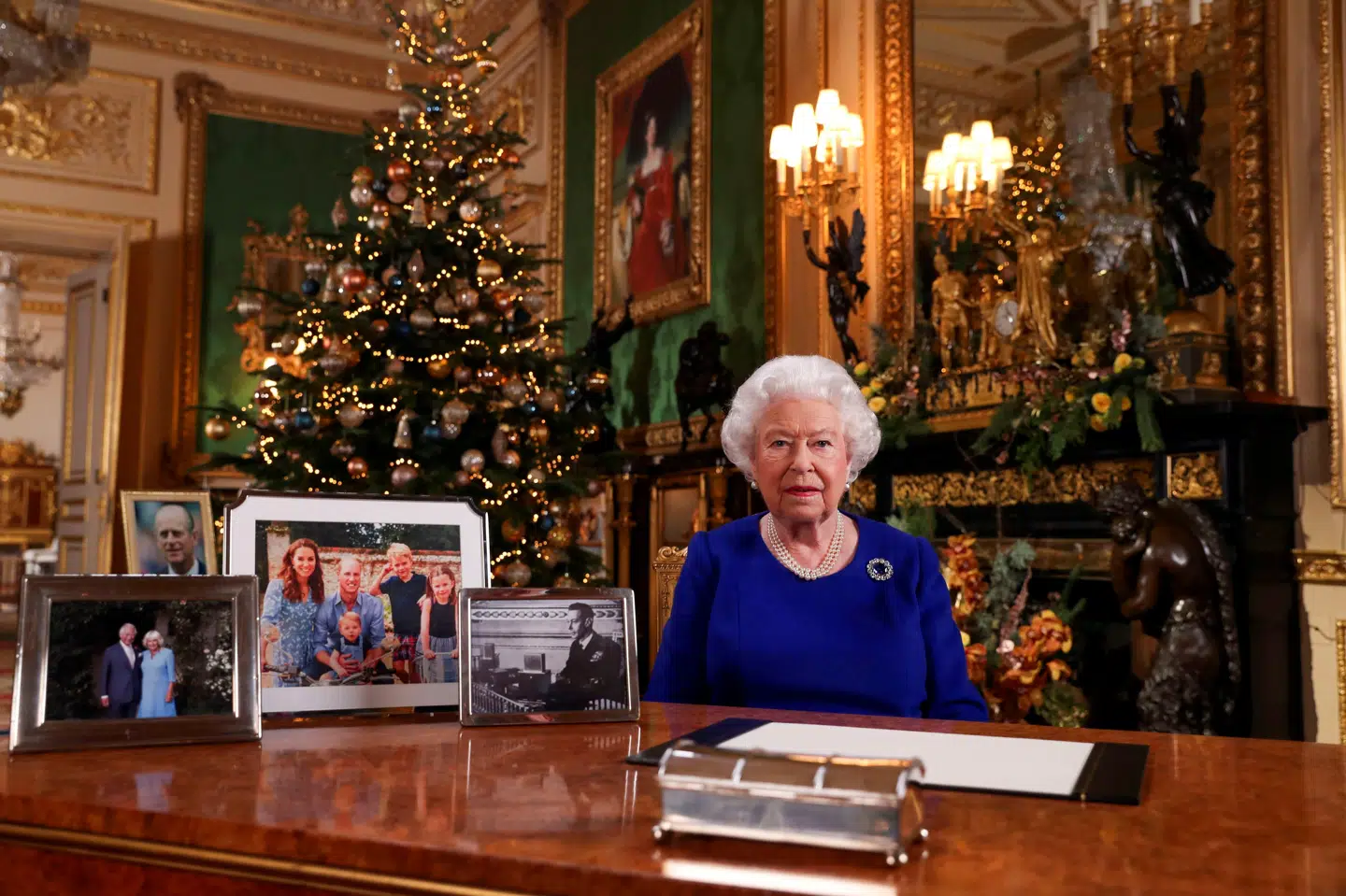 Britiske aviser bider mærke i, at to familiemedlemmer ikke er med på nogen af de fotos, dronning Elizabeth har på skrivebordet under sin juletale fra Windsor Castle. Prins Andrew slap skidt fra forsvar mod overgreb, og prins Harry synes at rage uklar med familien. Pool New/Reuters