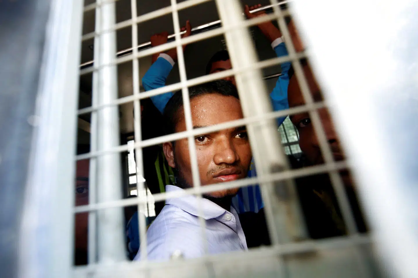 En muslimsk mand fra Rohingya-stammen ser ud fra en polititransportbil.
