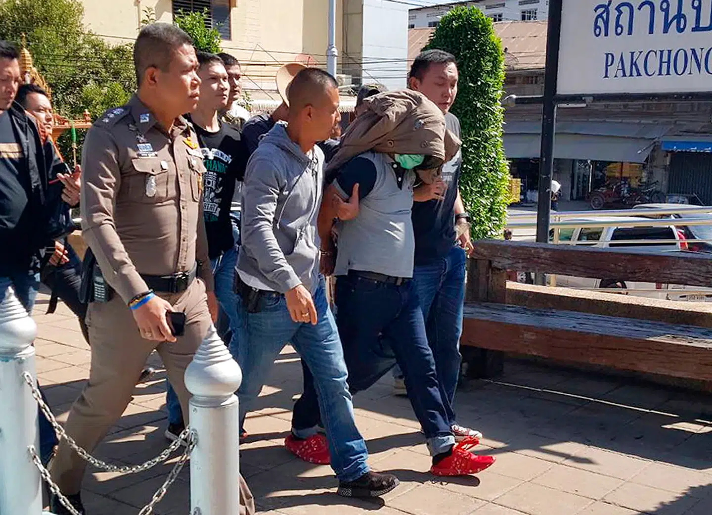 Her bliver Somkid Pumpuang ført til retten af to thailandske politibetjente.