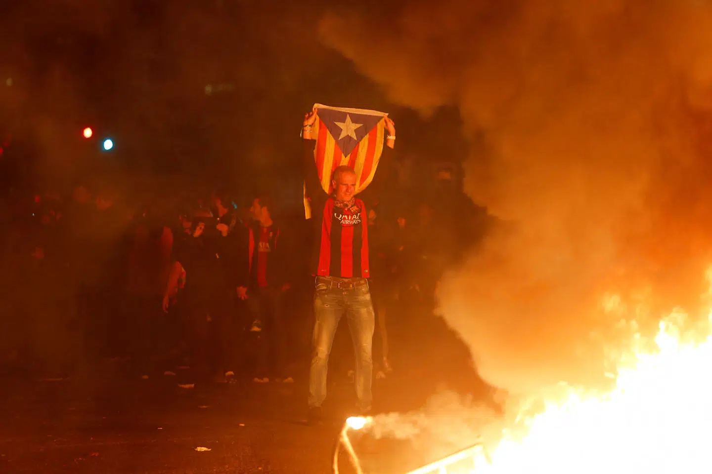 Soccer Football - La Liga Santander - FC Barcelona v Real Madrid - Barcelona, Spain - December 18, 2019 A Barcelona fan in support of Catalan independence looks on at a fire as protestors gather in Barcelona REUTERS/Enrique Calvo