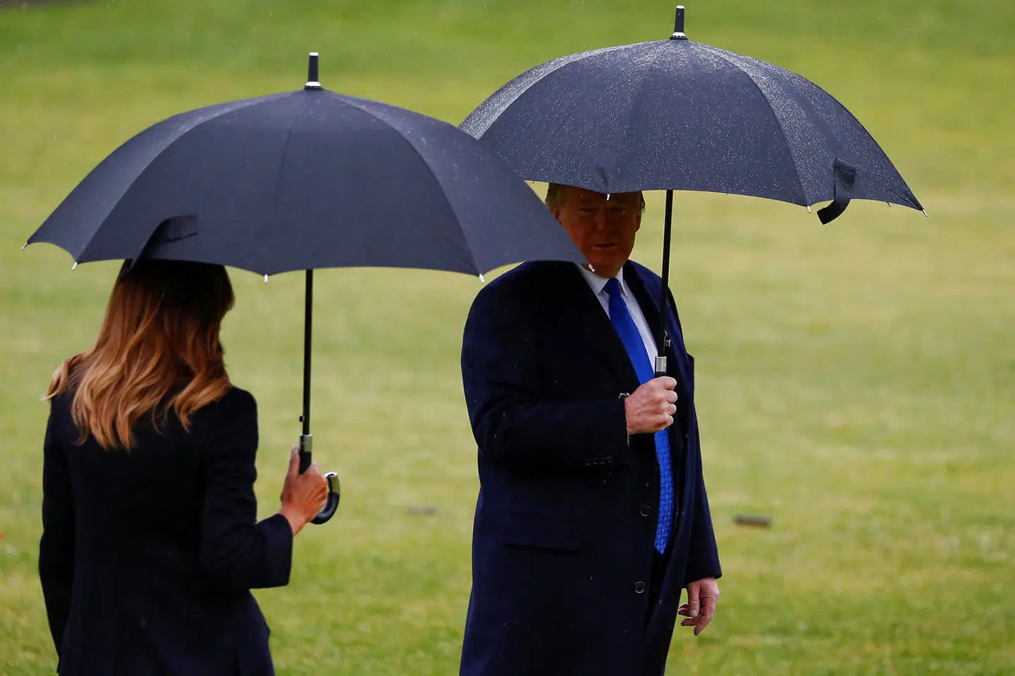 Melania og Donald Trump - under hver sin paraply.