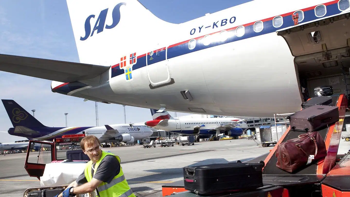 Arbejderne, der holder lufthavnes bagage kørende, kan gå og vente nervøst på et brev med en fyreseddel. Arkivfoto.