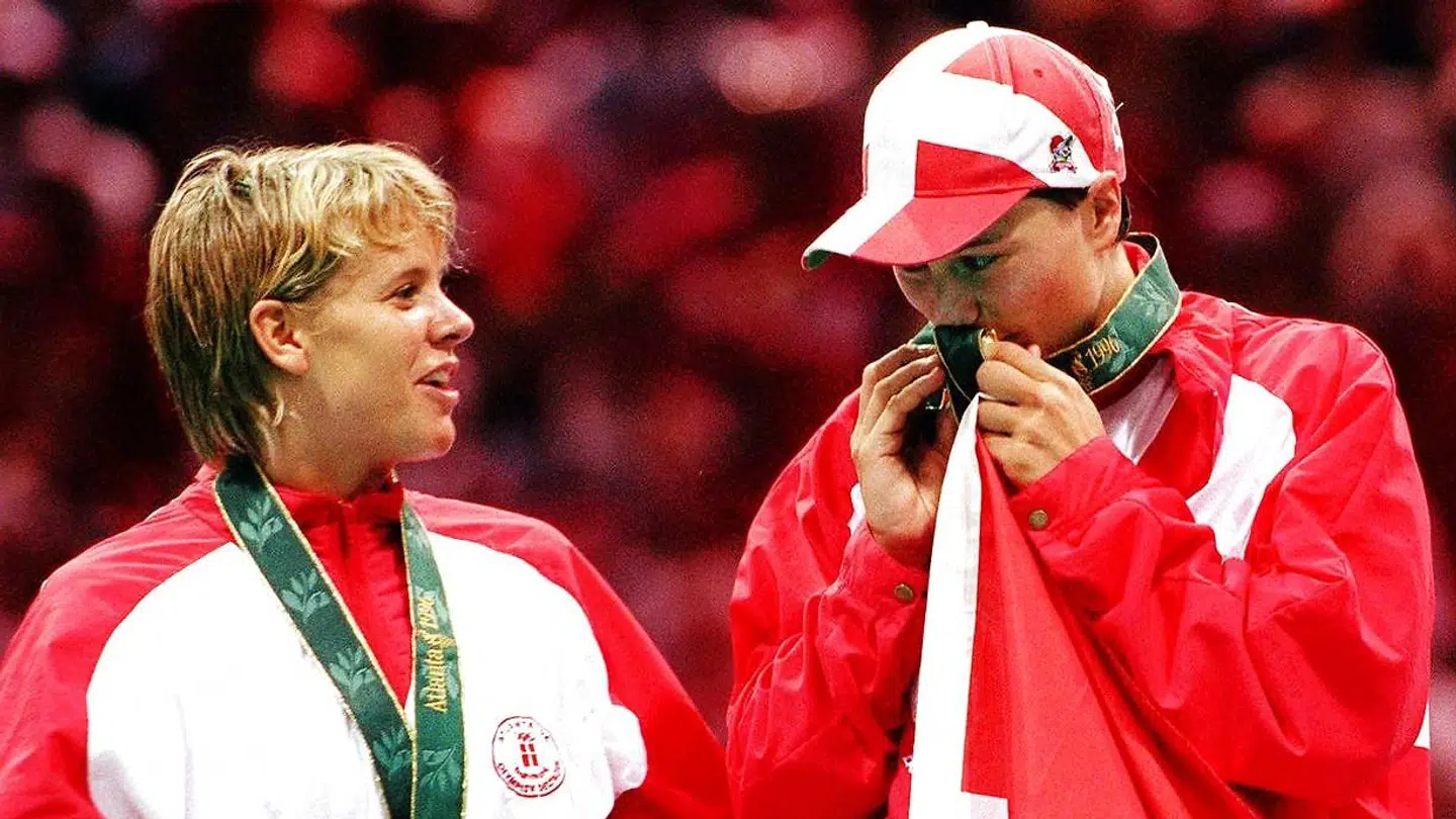 Conny Hamann kigger på Anja Andersen, der kysser guldmedaljen efter sejren ved OL i 1996.