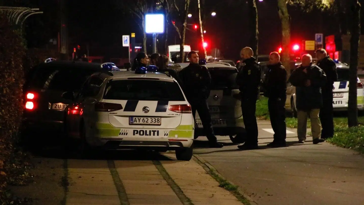 En større mængde politifolk og tre politibiler omkringer den stjålne bil, som to personer forsøgte at flygte fra politiet i.