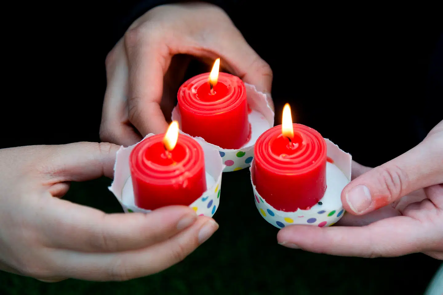 Tre kvinder holder lys ved en mindestund for Grace Millane.