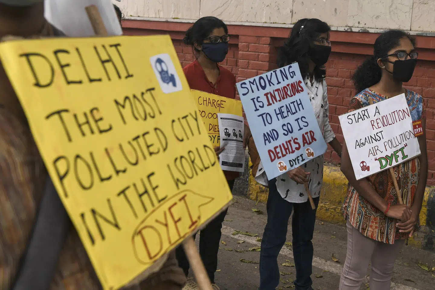 Demonstranter med masker protesterer mod smog i New Delhi, hvor forureningen er nået op på et uudholdeligt niveau ifølge New Delhis chefminister, Arvind Kejriwal. Sajjad Hussain/Ritzau Scanpix