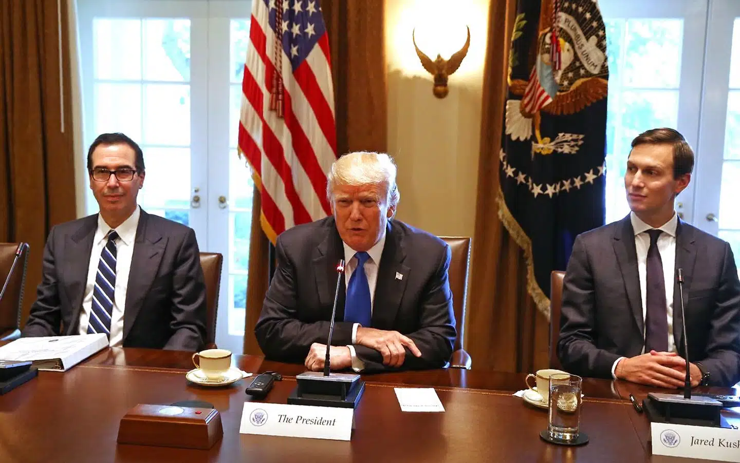 Præsident Donald Trump flankeret af svigersøn, Jared Kushner og skatteminister Steven Mnuchin.