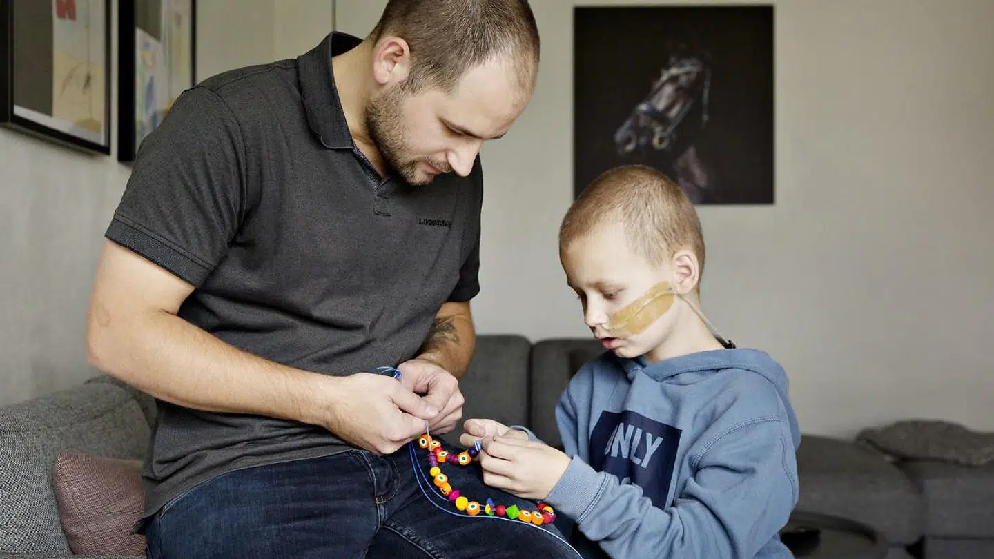 Magnus kigger sin supersnøre med sin far, Claus Funder Nielsen. Hver gang han har fået en behandling på sygehuset, får han en ny perle.