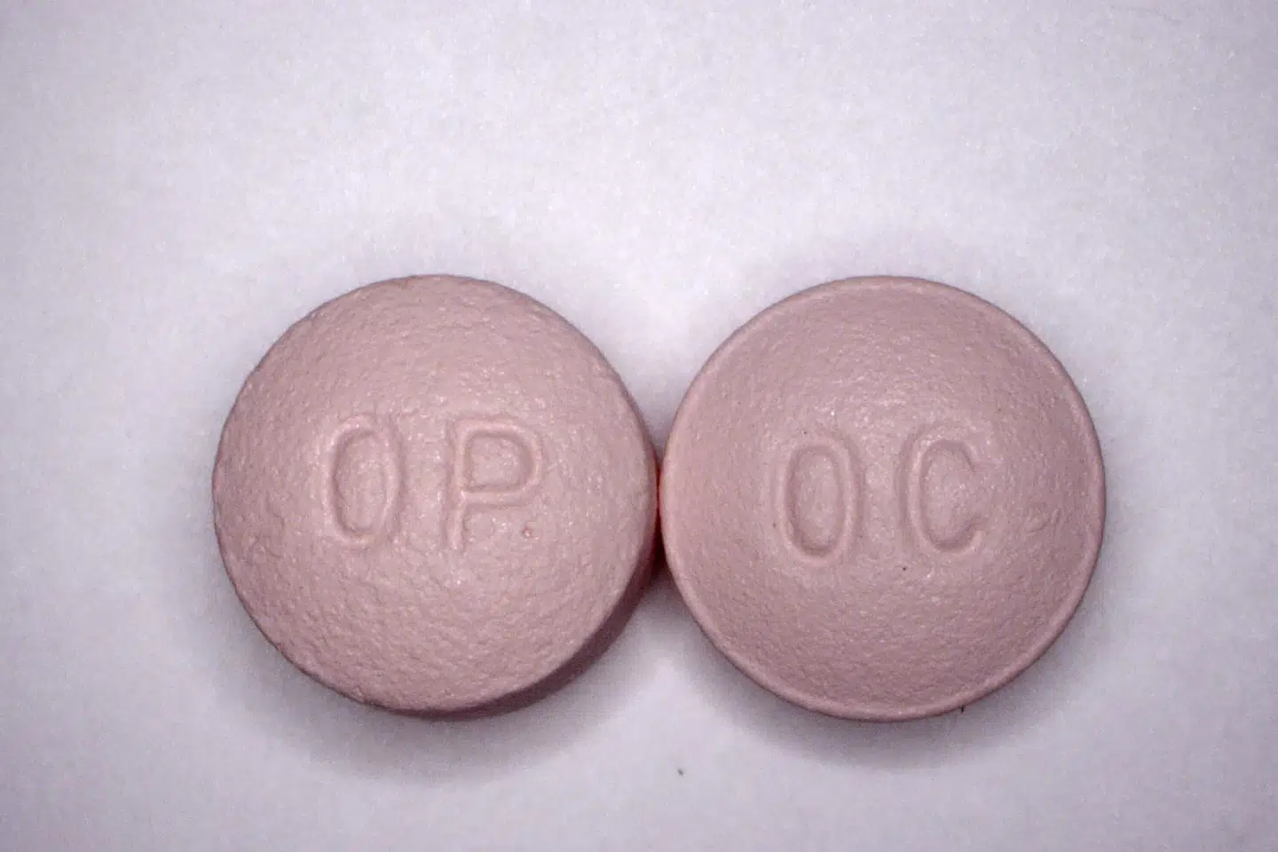 To 20 mg piller af det stærkt smertedæmpende og stærkt vanedannede OxyContin. Det er piller som disse, der har gjort hundredtusinder af amerikanere til narkomaner. Medicinalselskaberne anklages for at have været skruppelløse i deres markedsføring af opioiderne. Handout/Ritzau Scanpix