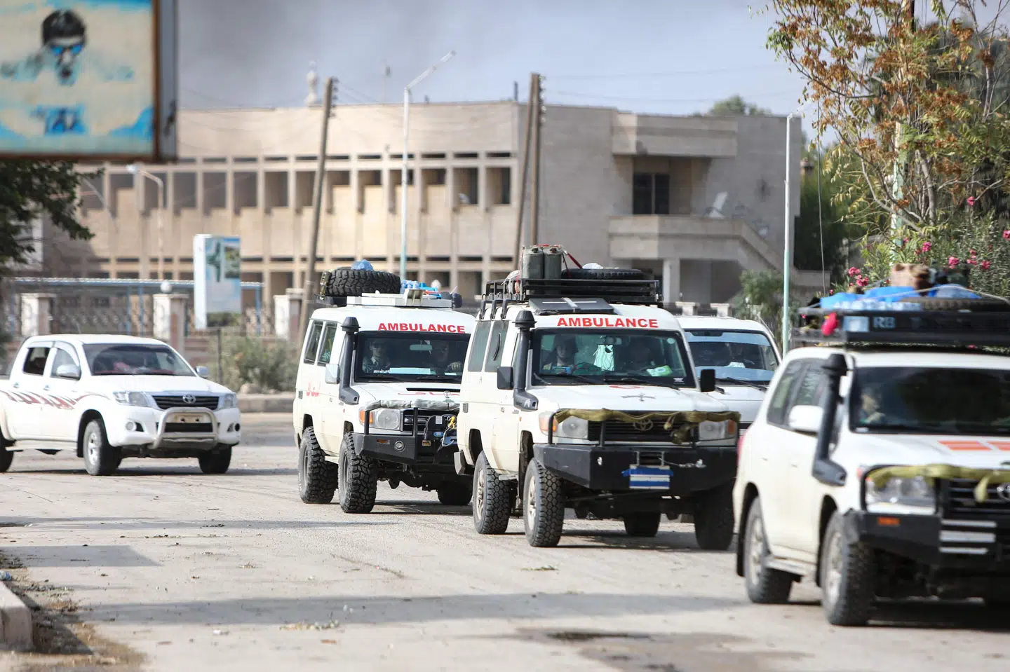 En konvoj af ambulancer evakuerer sårede civile og medlemmer af den kurdiskledede styrke Syriske Demokratiske Styrker (SDF) fra Ras al-Ain søndag. Nazeer Al-Khatib/Ritzau Scanpix