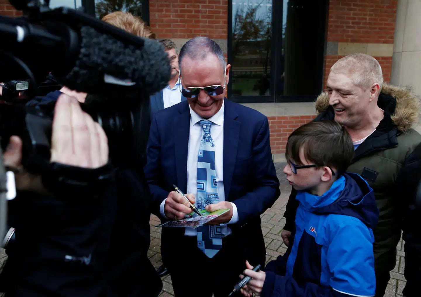 Paul Gascogine ses her skrive en autograf foran retten.