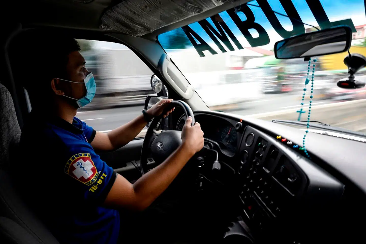 Ambulancefolk kæmper med at holde tilbage i myldretidstratikken i Manila.