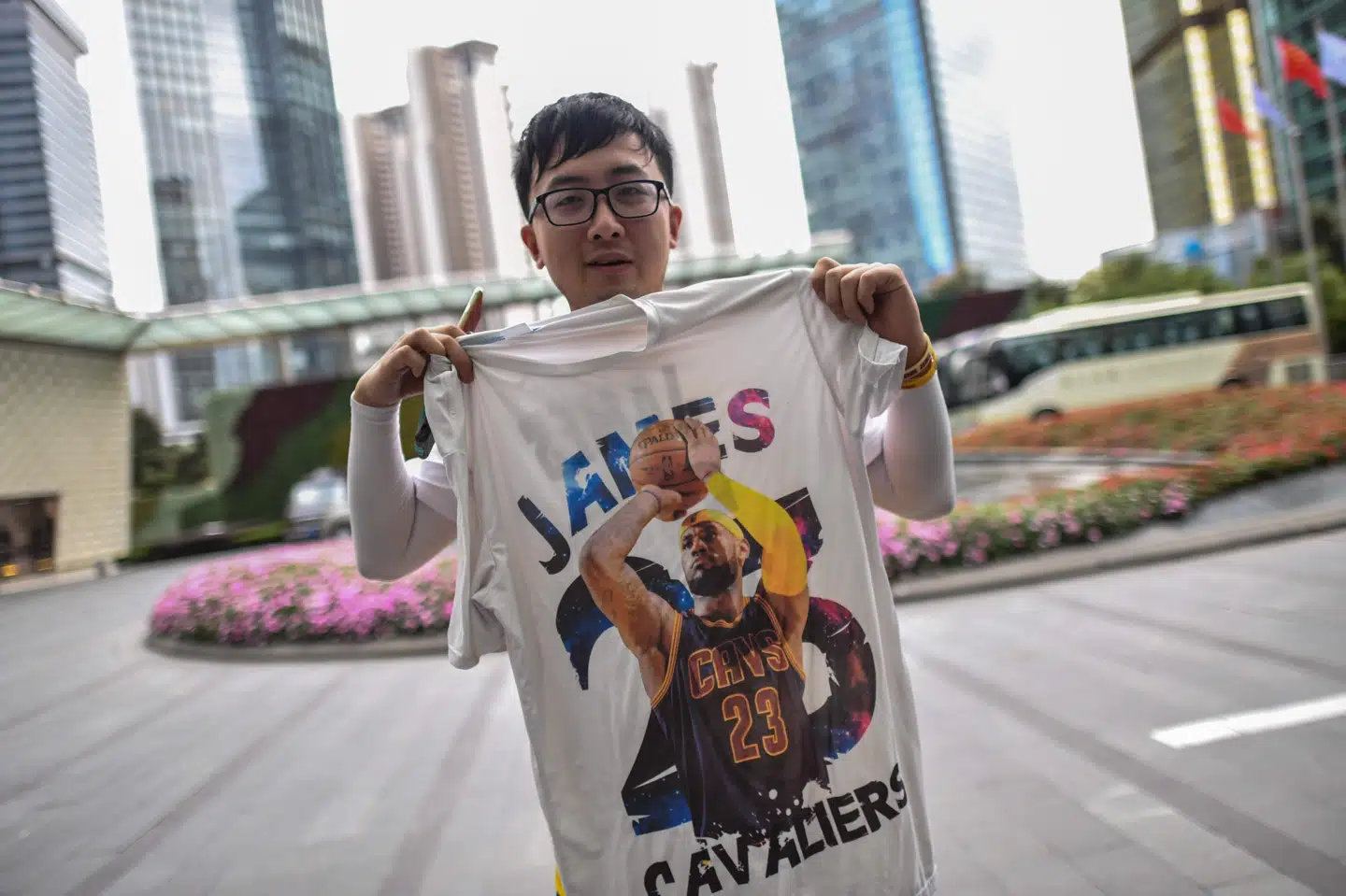 En fan fremviser en t-shirt med basketspilleren LeBron James uden for et hotel i Shanghai, hvor han håber på at få et glimt af NBA-stjerner inden en opvisningskamp mellem Brooklyn Nets og The Los Angeles Lakers. Hector Retamal/Ritzau Scanpix