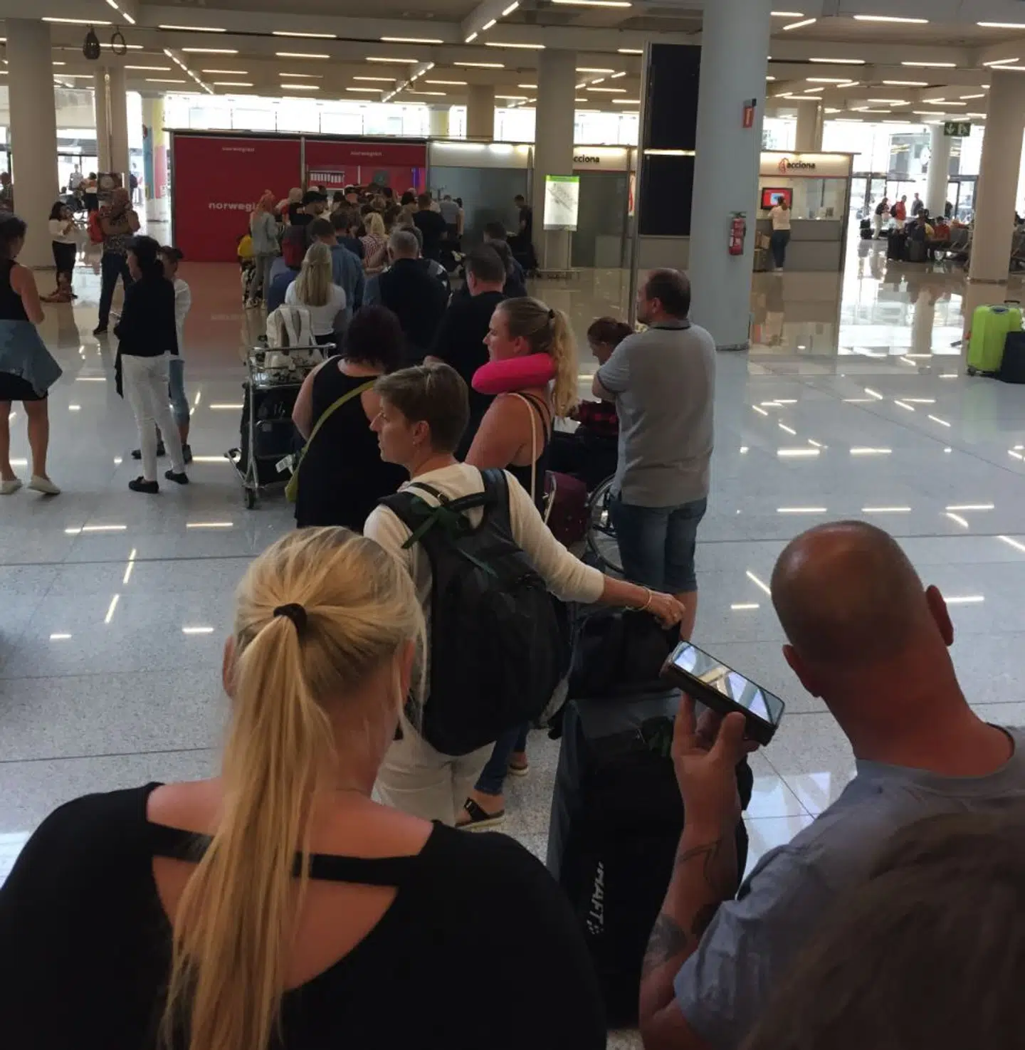 Køen til Norwegians skranke i Palma Lufthavn var fredag så lang, at folk ventede 4-5 timer for at få svar på, hvordan de skulle komme videre fra lufthavnen.