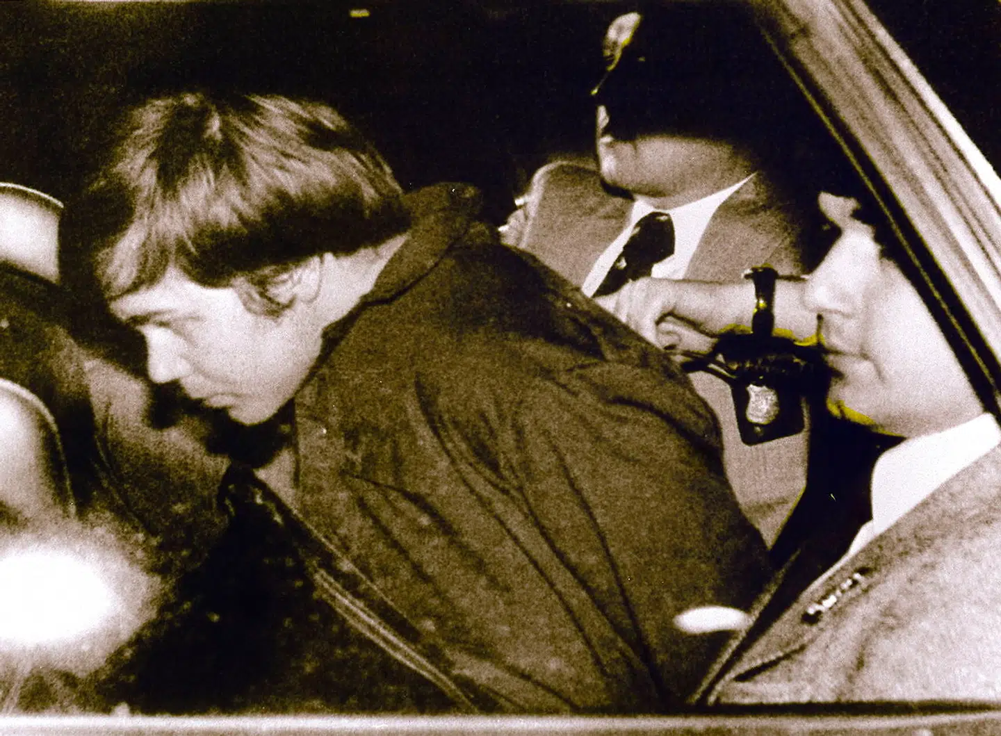 John Hinckley Jr. (tv.) eskorteres af politiet efter at være blevet arresteret.