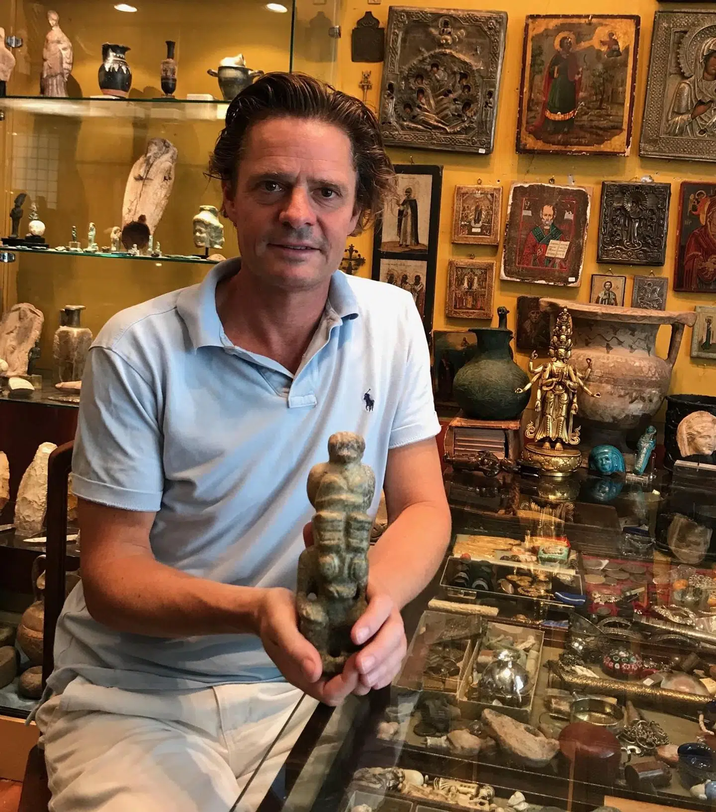 Oliver Klitgaard sidder her i sin butik med den jadefigur, som han har gemt til minde om prins Henrik. Figuren lå hos forhandleren og var tiltænkt prinsen, som dog aldrig nåede at få den. Nu har Oliver Klitgaard beholdt den til minde om sin ven.