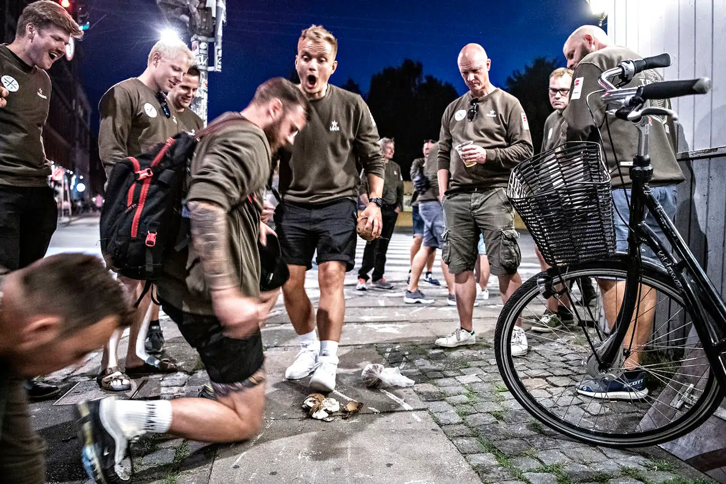 På Nørrebrogade ved Det Rene Glas er drengene ved at smadre kokosnødder med de bare håndflader og albuer. Det går selvfølgelig galt.