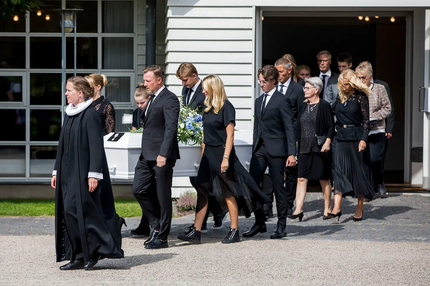 Kisten bæres ud. Forrest går Lars Larsens to børn, Mette Brunsborg og Jacob Brunsborg, og bag kisten går hans hustru, Kristine Brunsborg.