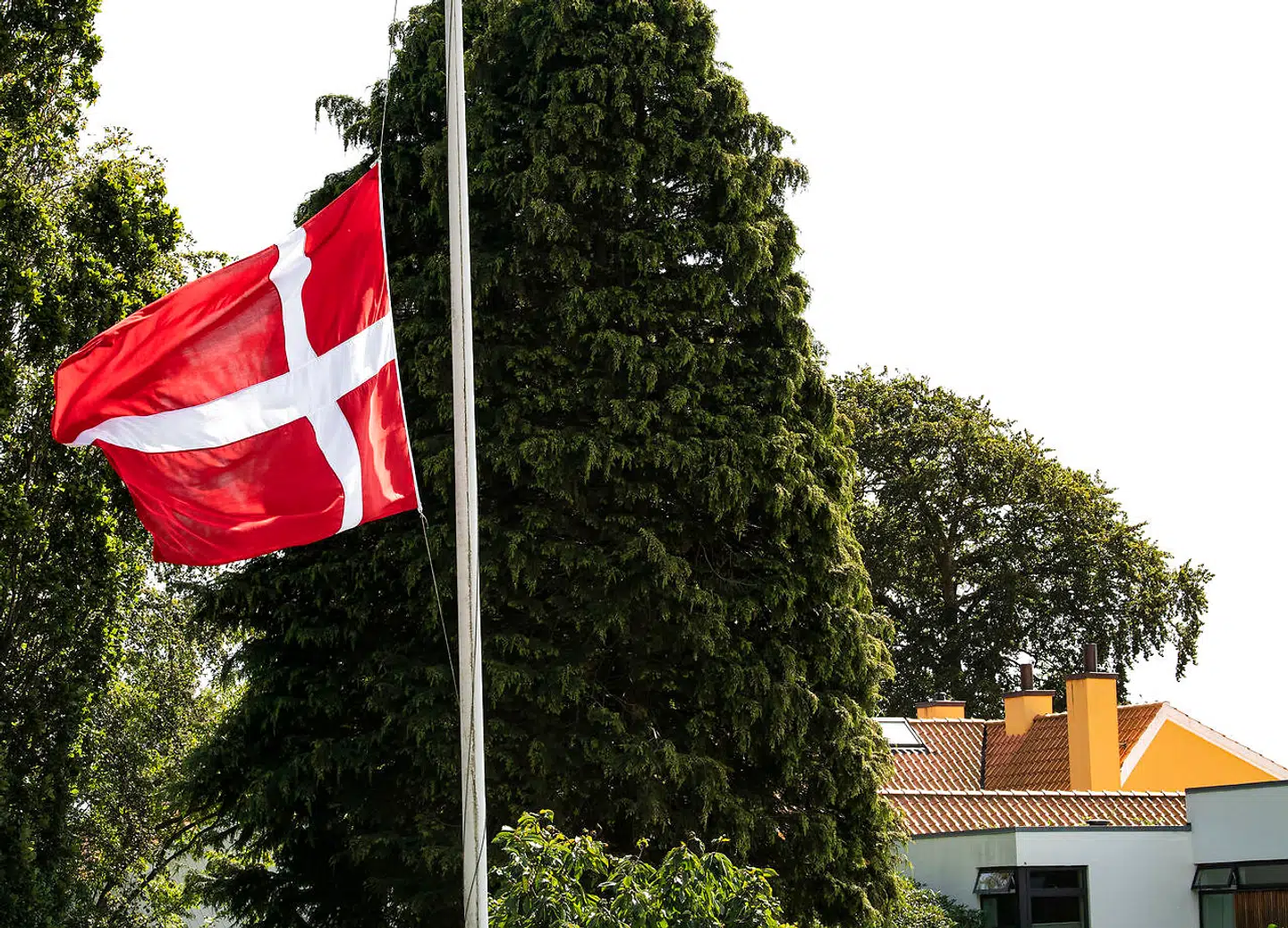 Naboerne satte flagene på halv, da den triste nyhed om Lars Larsens død blev kendt på vejen. Den gule villa i baggrunden er familien Brunsborg Larsens hjem.