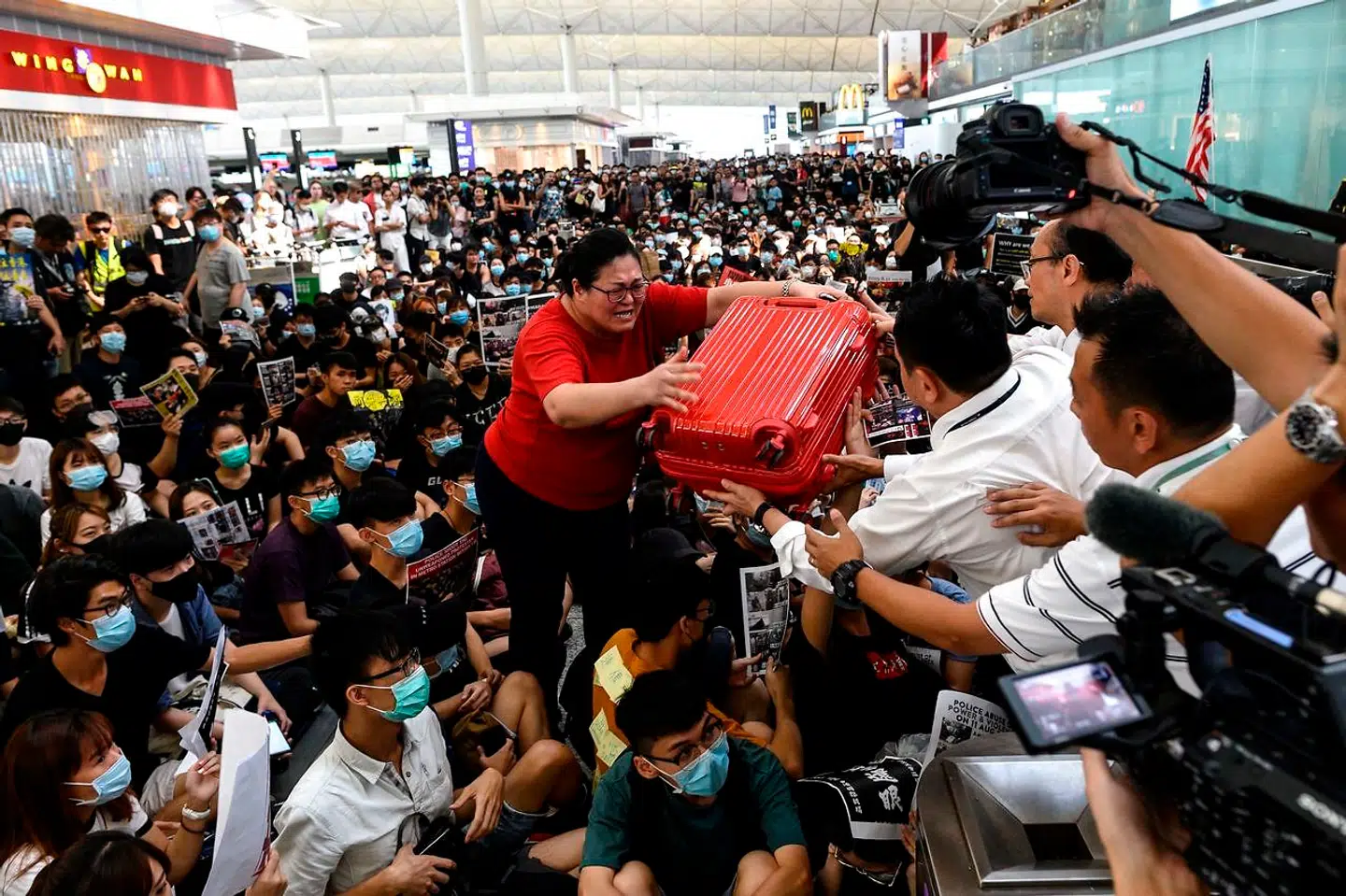 Kaotiske tilstande hersker i lufthavnen i Hong Kong, hvor hundredevis af demonstranter har blokeret for tjek in.