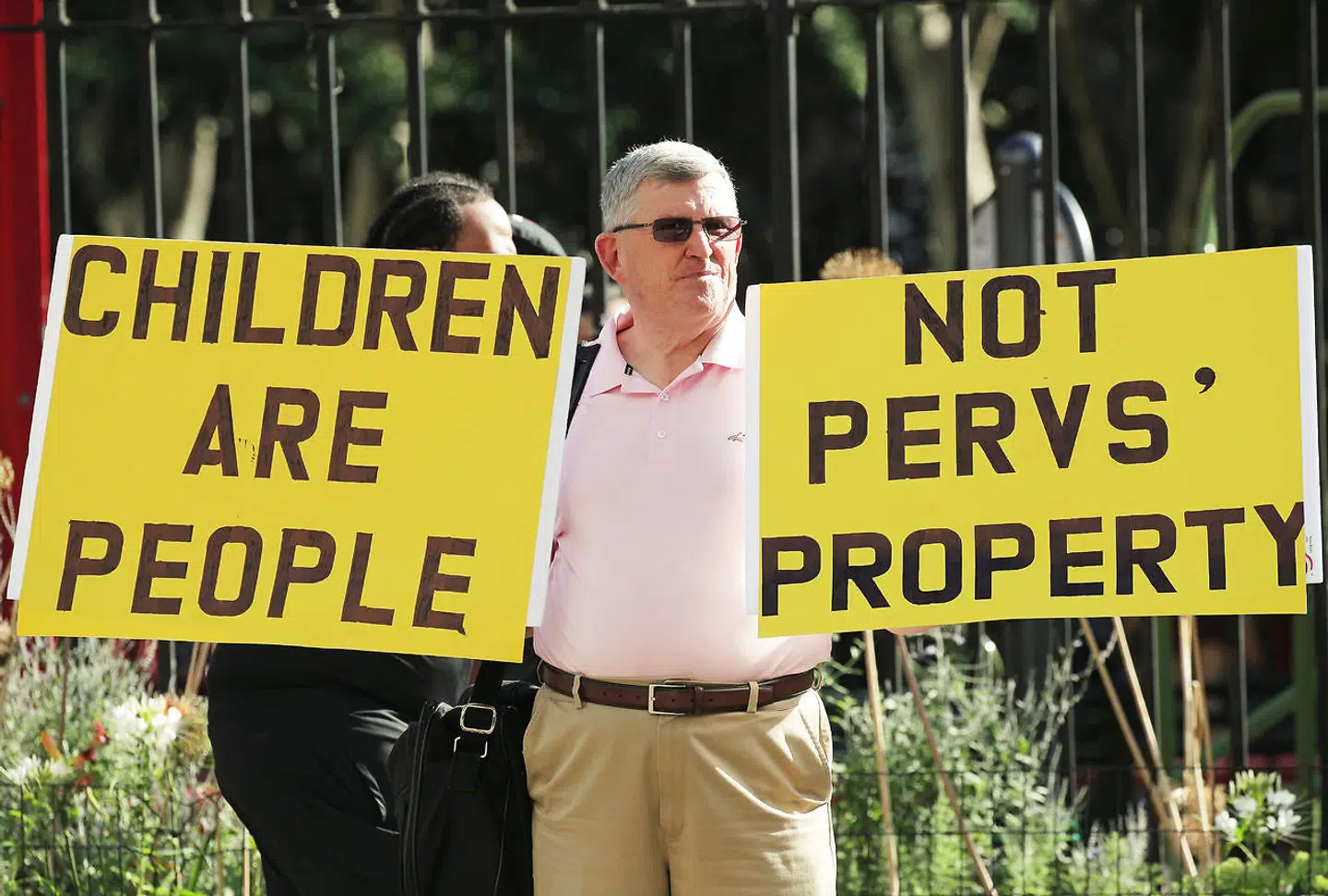 A protester holds up signs outside the courthouse ahead of a bail hearing in U.S. financier Jeffrey Epstein's sex trafficking case in New York City, U.S. July 15, 2019. REUTERS/Brendan McDermid
