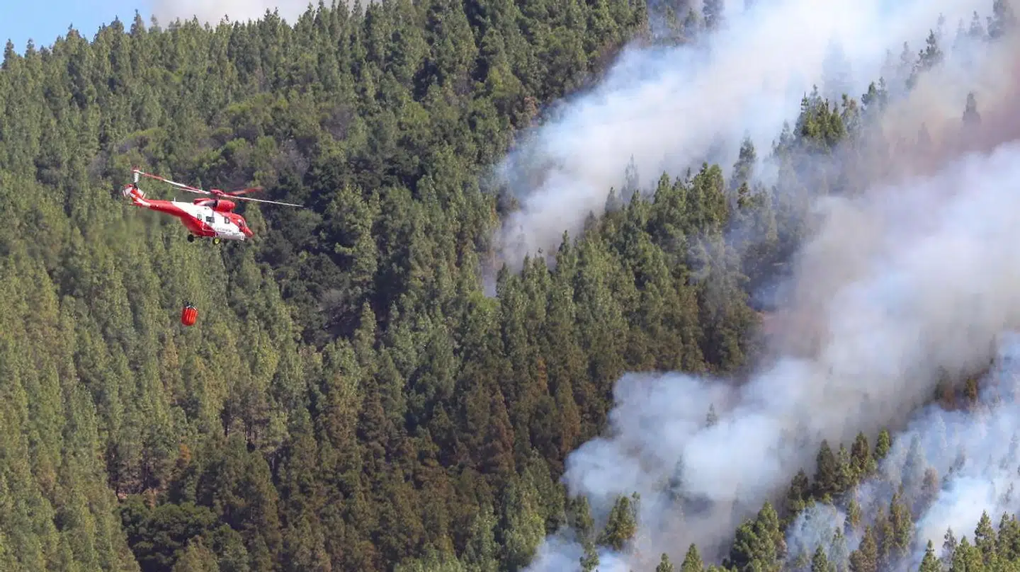 En helikopter hjælper til med at slukke skovbranden.