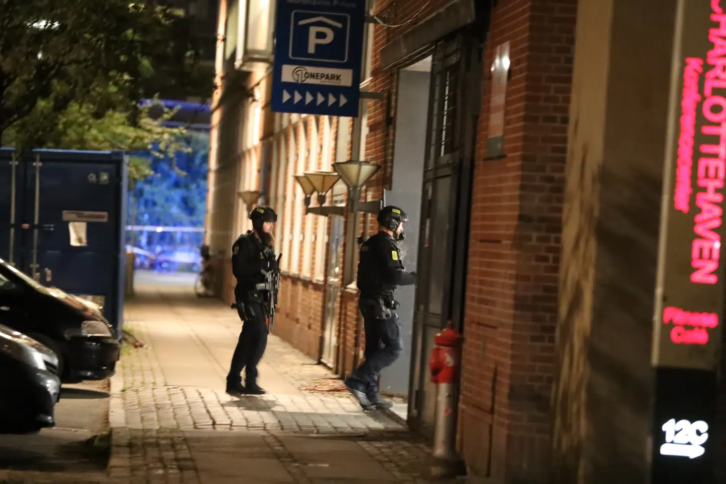 Kampklædre betjente afsøger området med maskinpistoler.
