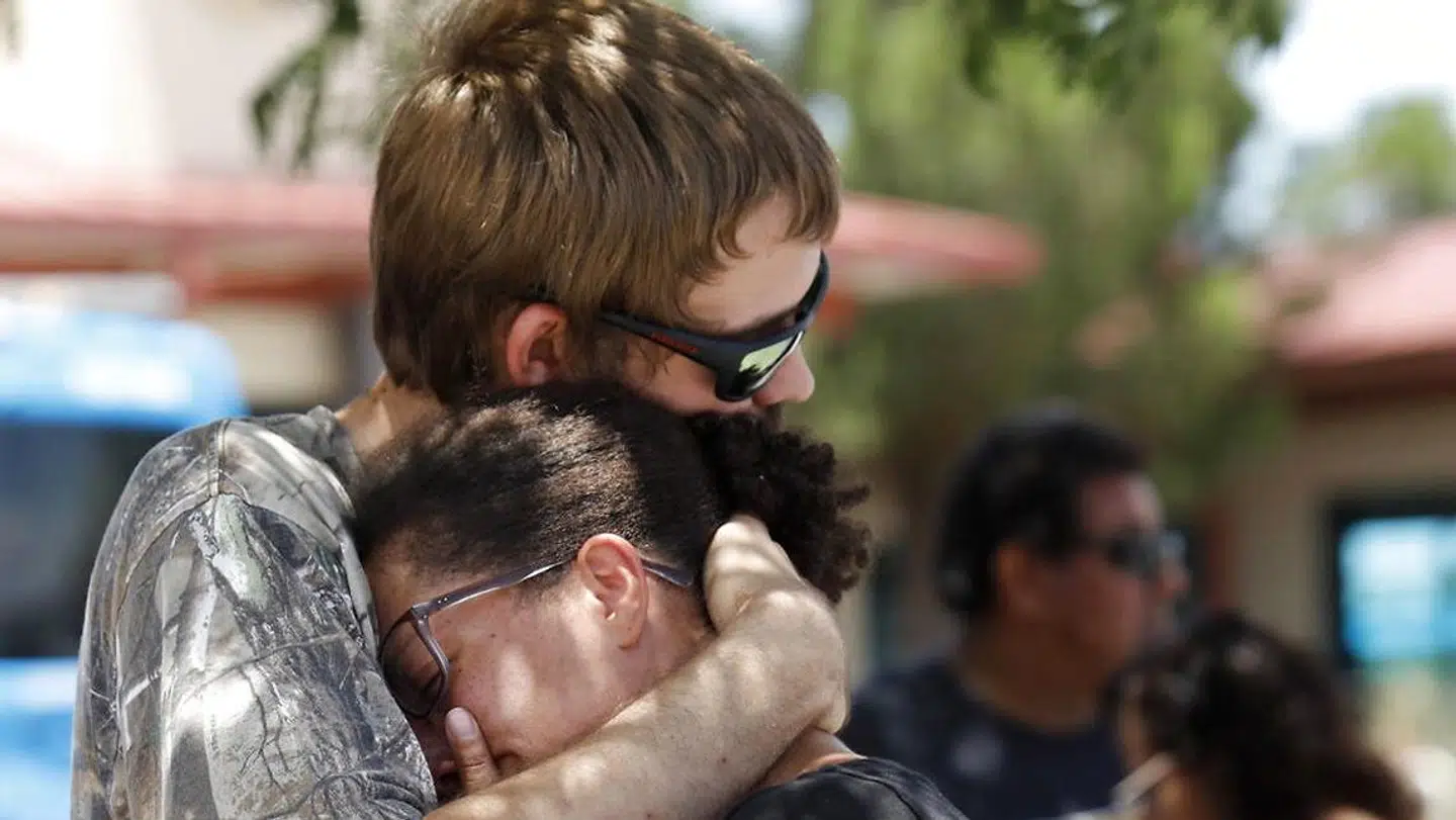 Kendall Long (tv.) trøster Kianna Long (th.), som var i centrets køleafdeling, da skyderierne.