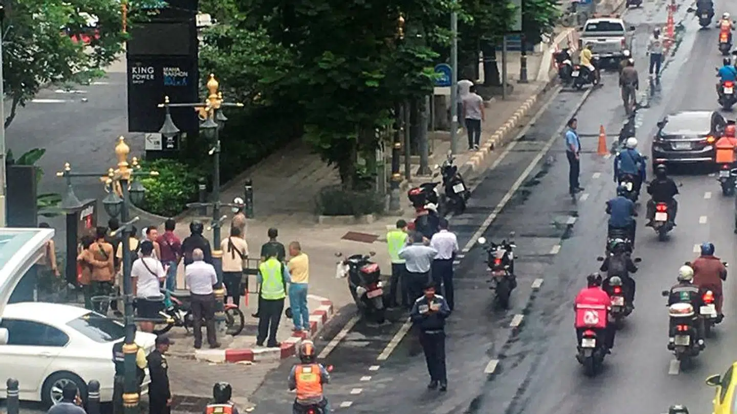 En mindre menneskemængde forsamlet i nærheden af en eksplosionerne i Bangkok.
