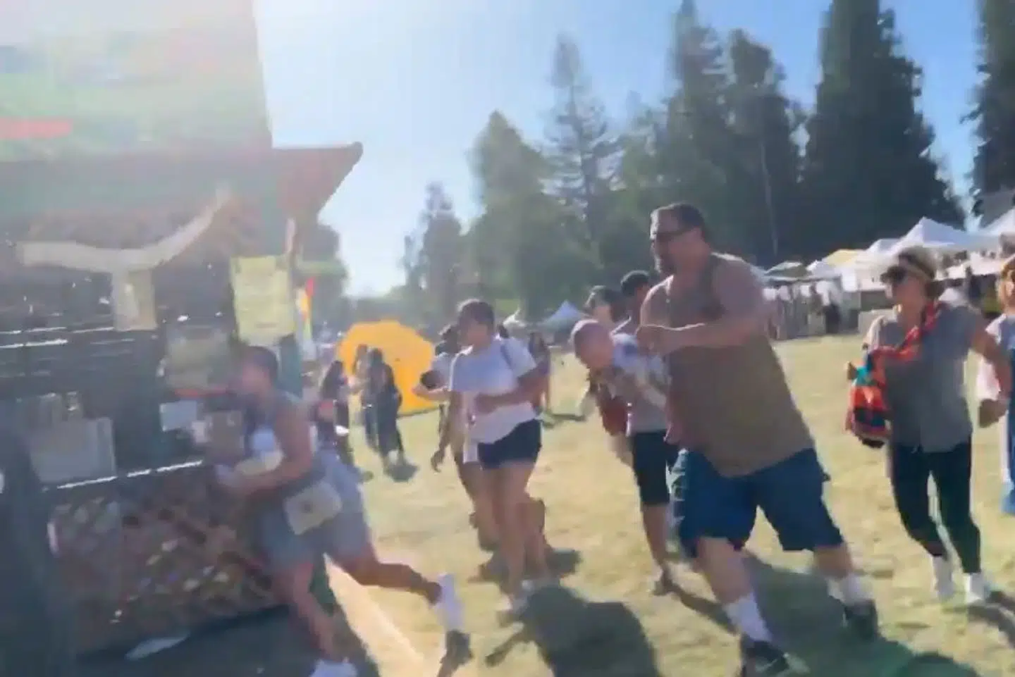 I et billede, der er taget af en video fra en madfestival i Californien, kan man se, hvordan personer løber væk fra et skyderi. Social Media/Ritzau Scanpix