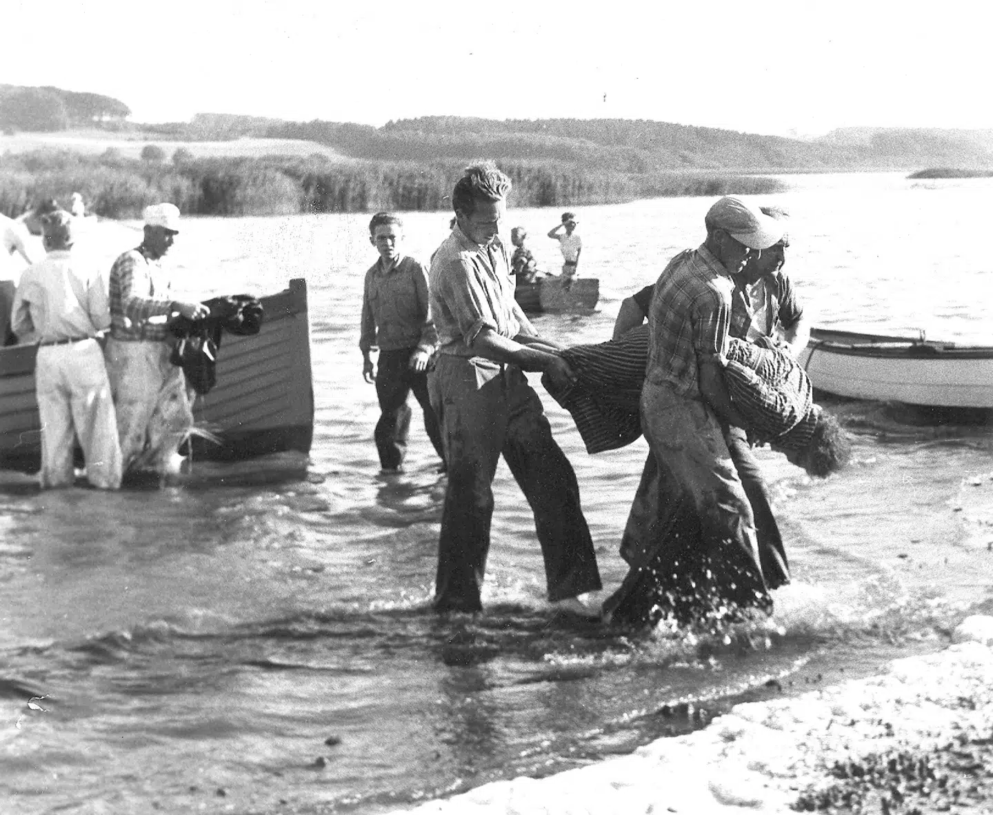 De omkomne bæres i land af de civile redningsmænd.