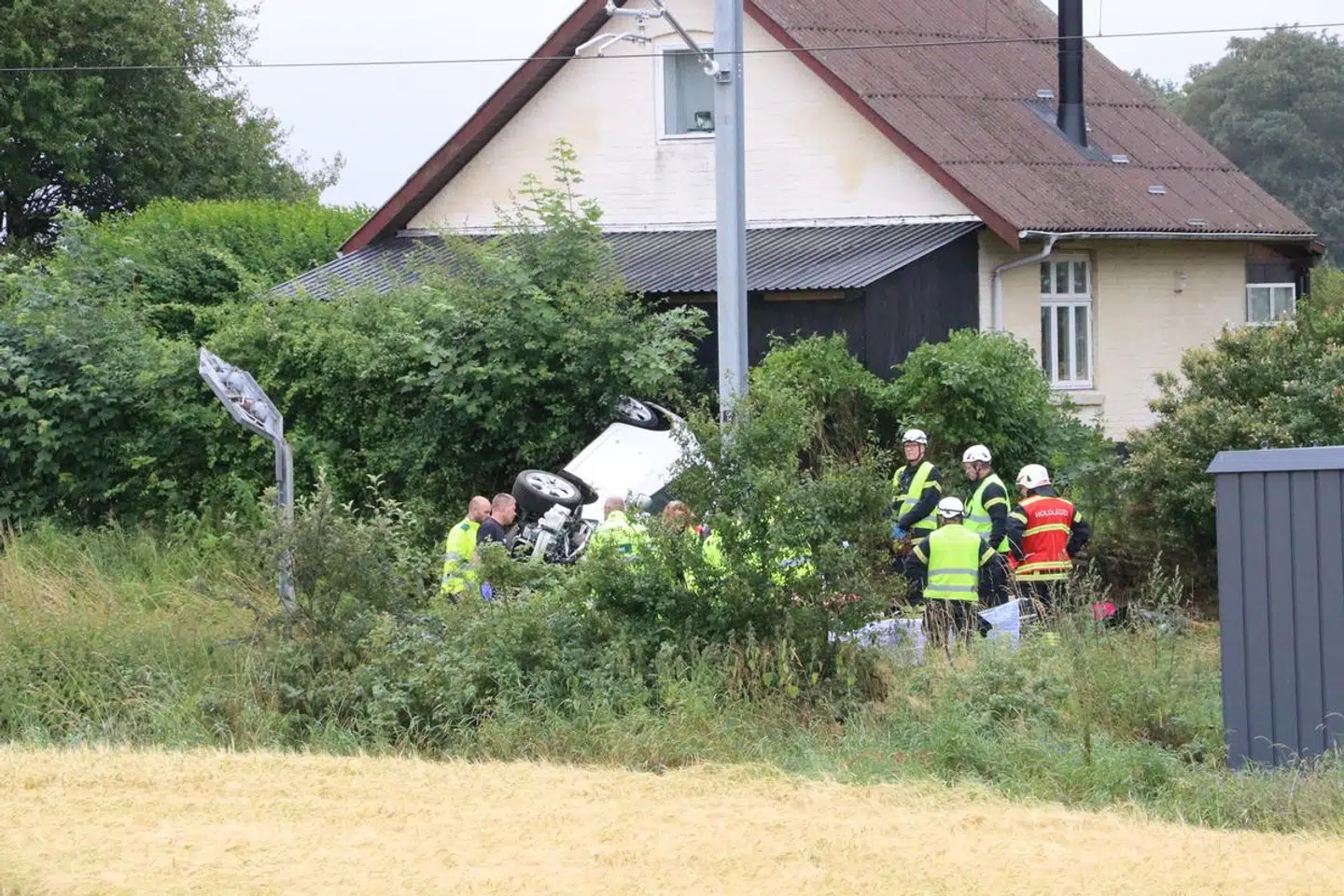 En bil er væltet om på siden efter sammenstødet. Foto: ØXENHOLT FOTO