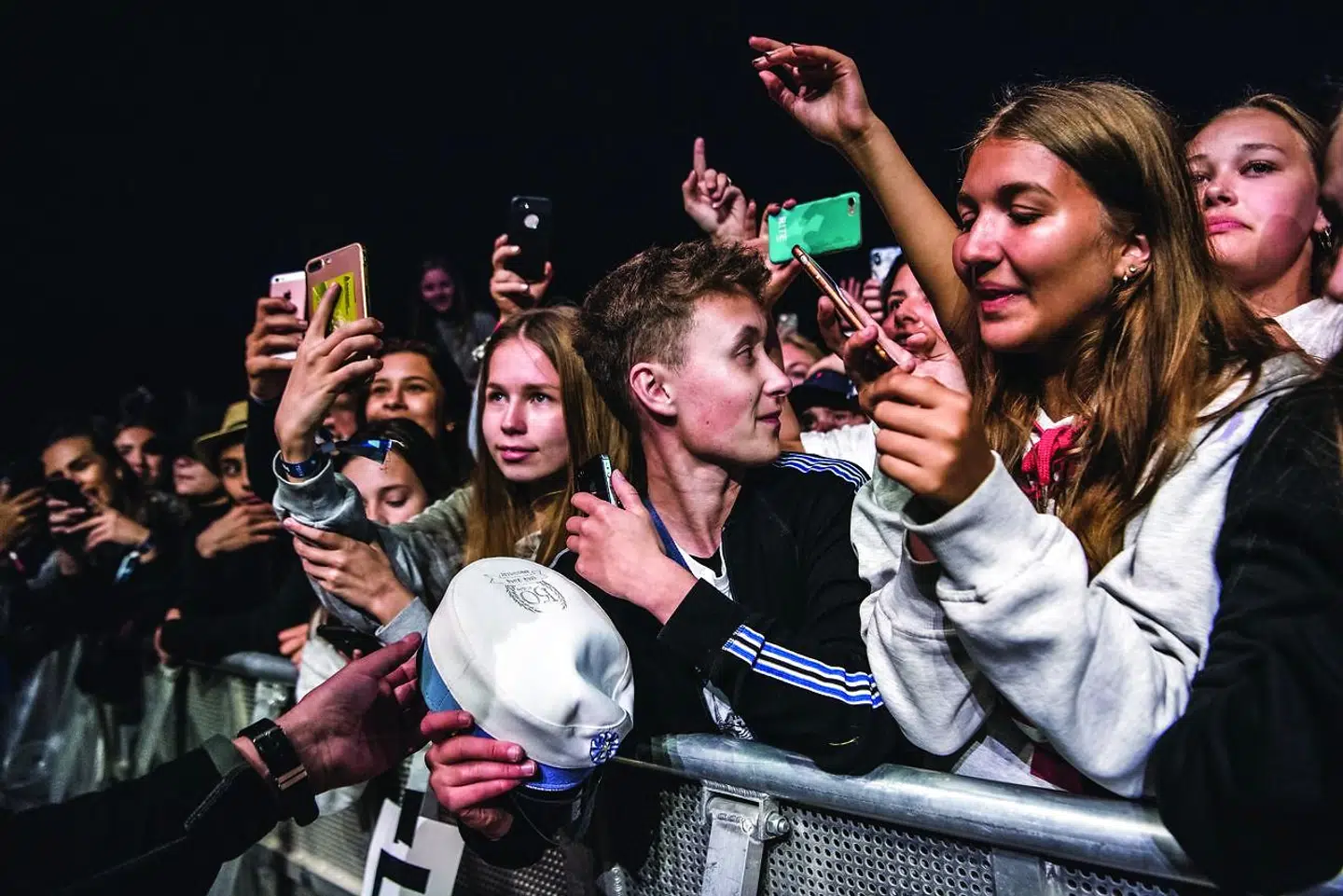 En af Kristian Viballes venner foran hjælper med at få huen frem til Miley Cyrus.