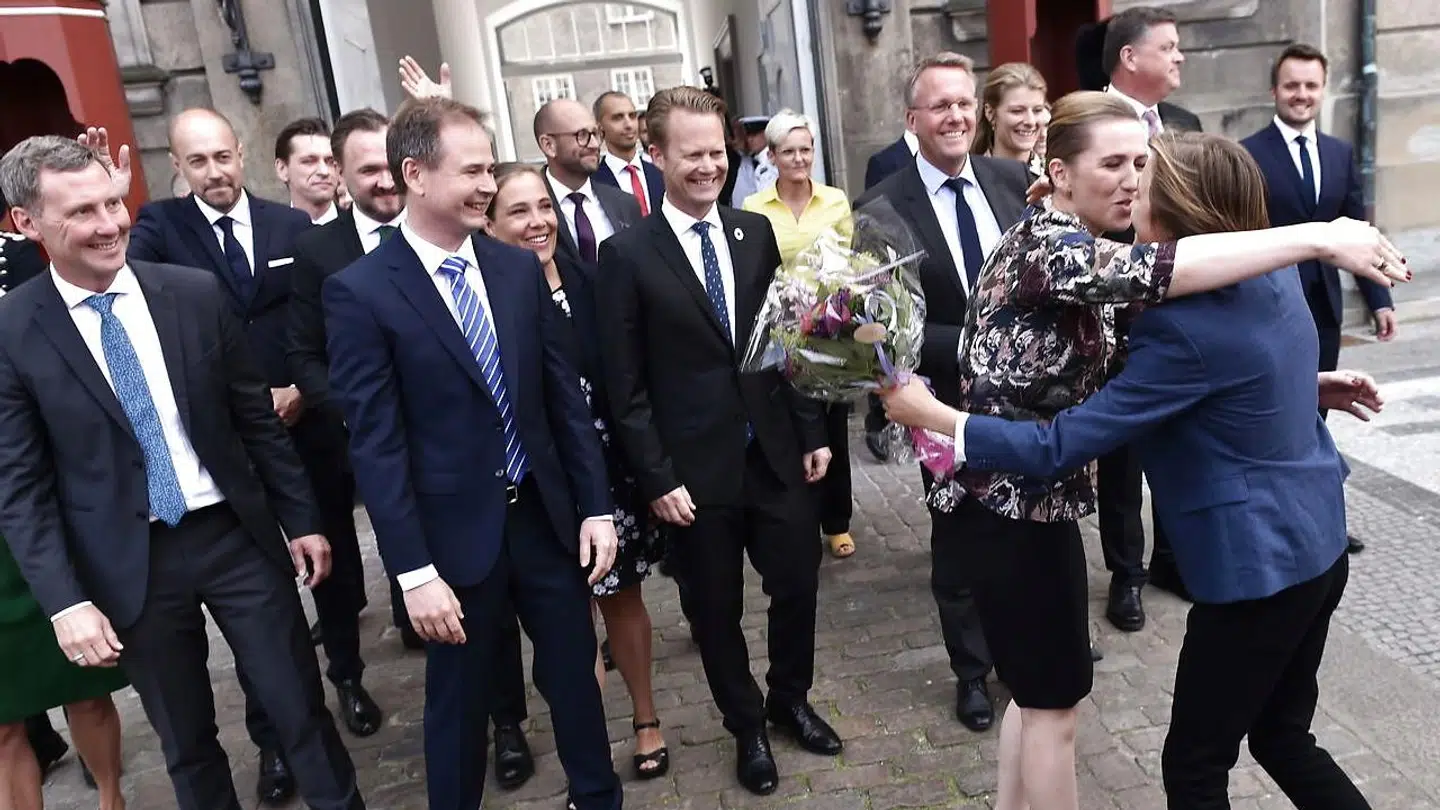 Mette Frederiksen får blomster af sin søn Magne, efter hun præsenterde den nye S-regering på Amalienborg i København.