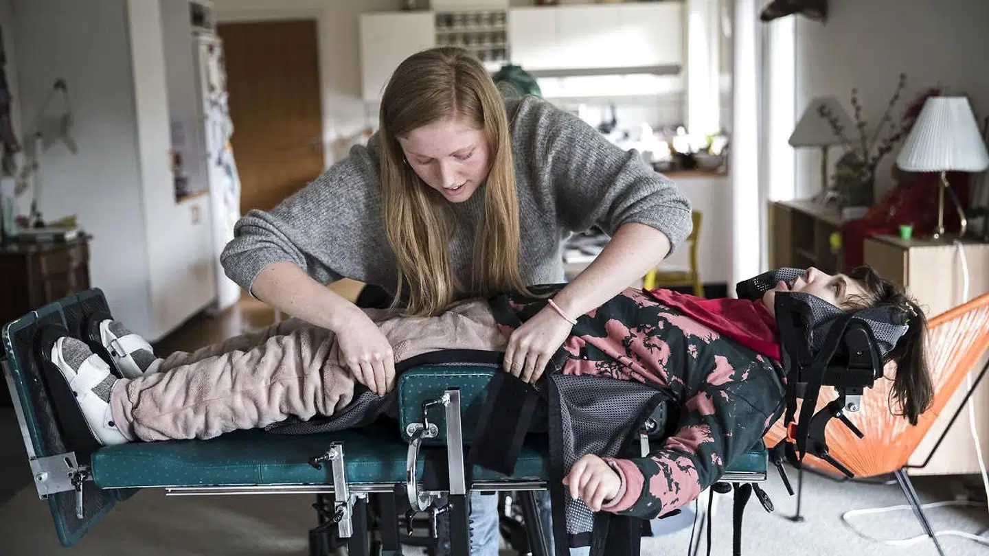Hjælperen Louise placerer Liva i en maskine, hvor hun kan stå op. Det er vigtigt, at hun kommer op at stå, så hun ikke med tiden får knogleskørhed.