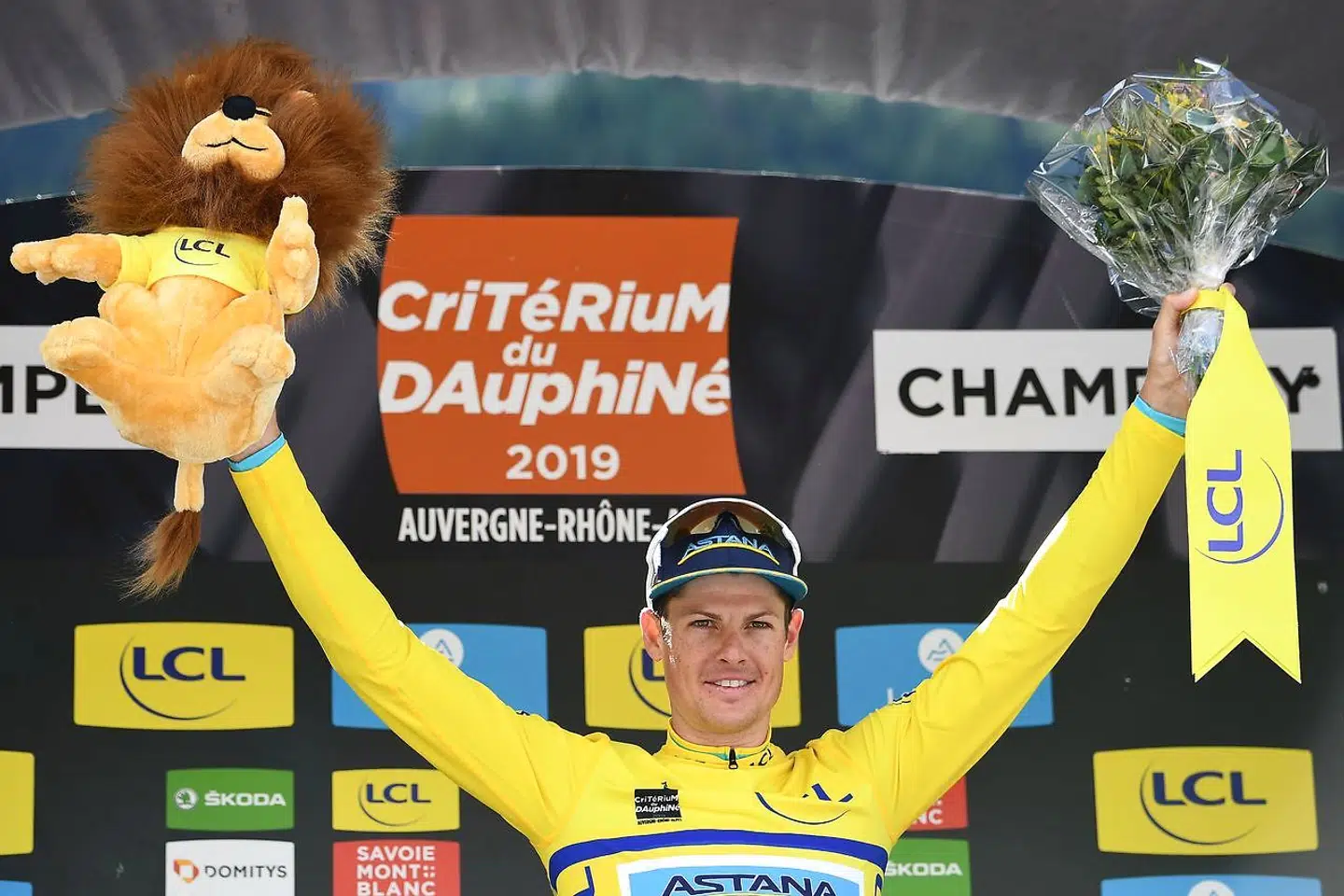 TOPSHOT - Astana Pro Team rider Denmark's Jakob Fuglsang celebrates his overall leader's yellow jersey on the podium of the eighth and last stage of the 71st edition of the Criterium du Dauphine cycling race, 113, 5 km between Cluses and Champery on June 16, 2019. (Photo by Anne-Christine POUJOULAT / AFP)