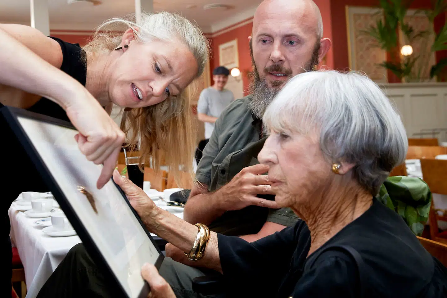 Lise Nørgaard modtager et billede af en paradisfugl i gave fra Helle og Uri.»Fuglen har mistet noget af sin hale. Det viser, at hvis vi ikke passer på paradiset, kan vi se, hvad vi står til at miste,« siger Helle.