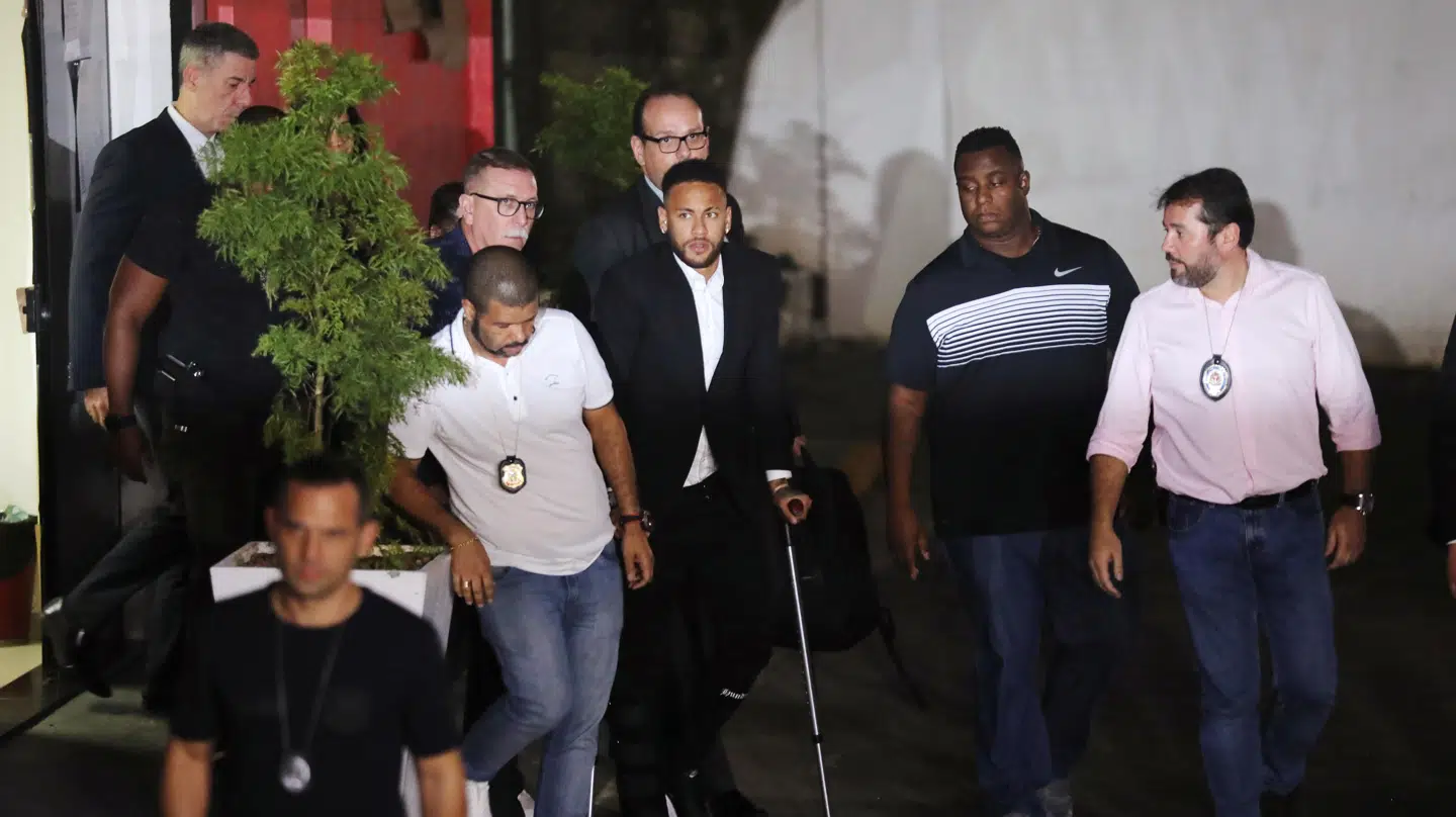 Neymar forlader politistationen i Sao Paulo omgivet af politi og sikkerhedsfolk.