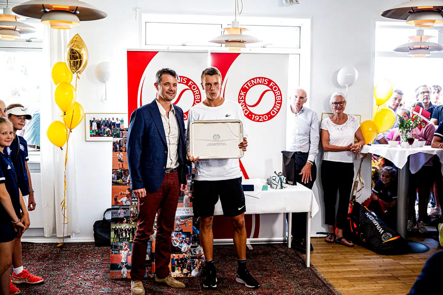 Tennisspilleren Holger Vitus Nødskov Rune, der tidligere på måneden vandt French Open for juniorer, hyldes af H.K.H. Kronprins Frederik i Hellerup Tennis Klub.