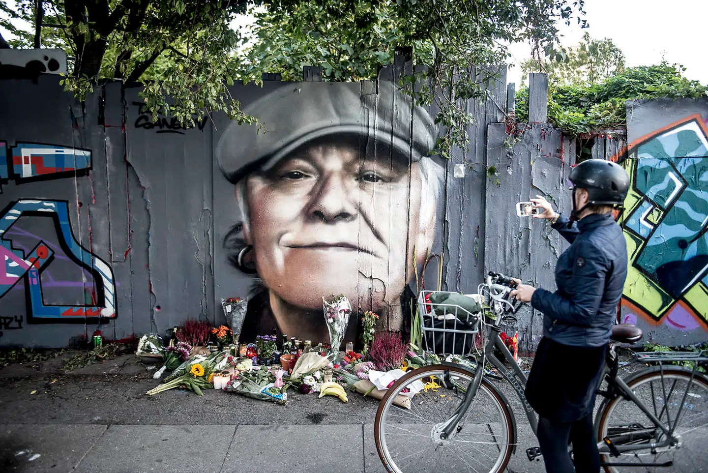 Blomster, øl, smøger og hilsner blev lagt foran det portræt der er blevet malet på hegnet ind mod Christiania på Prinsessegade i København til ære for danskernes nationalskjald Kim Larsen efter nationalskjaldens død 30. september 2018. (Foto: Mads Claus Rasmussen/Ritzau Scanpix)