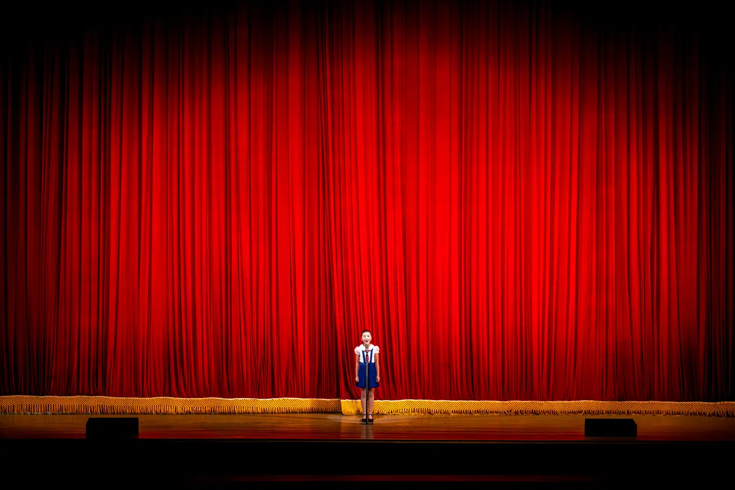 »Her ses et opvisningsshow fra skolen Childrens Palace, hvor særligt udvalgte kommende virtuose børn får uddannelse i instrumenter, dans eller sang. Her kommer en pige fra skolen ind og præsenterer showet. Det var den sidste aften, og jeg havde ikke mere i mig, og jeg havde faktisk pakket mit kamera sammen, men så nåede jeg alligevel at fange det her fantastiske motiv.«