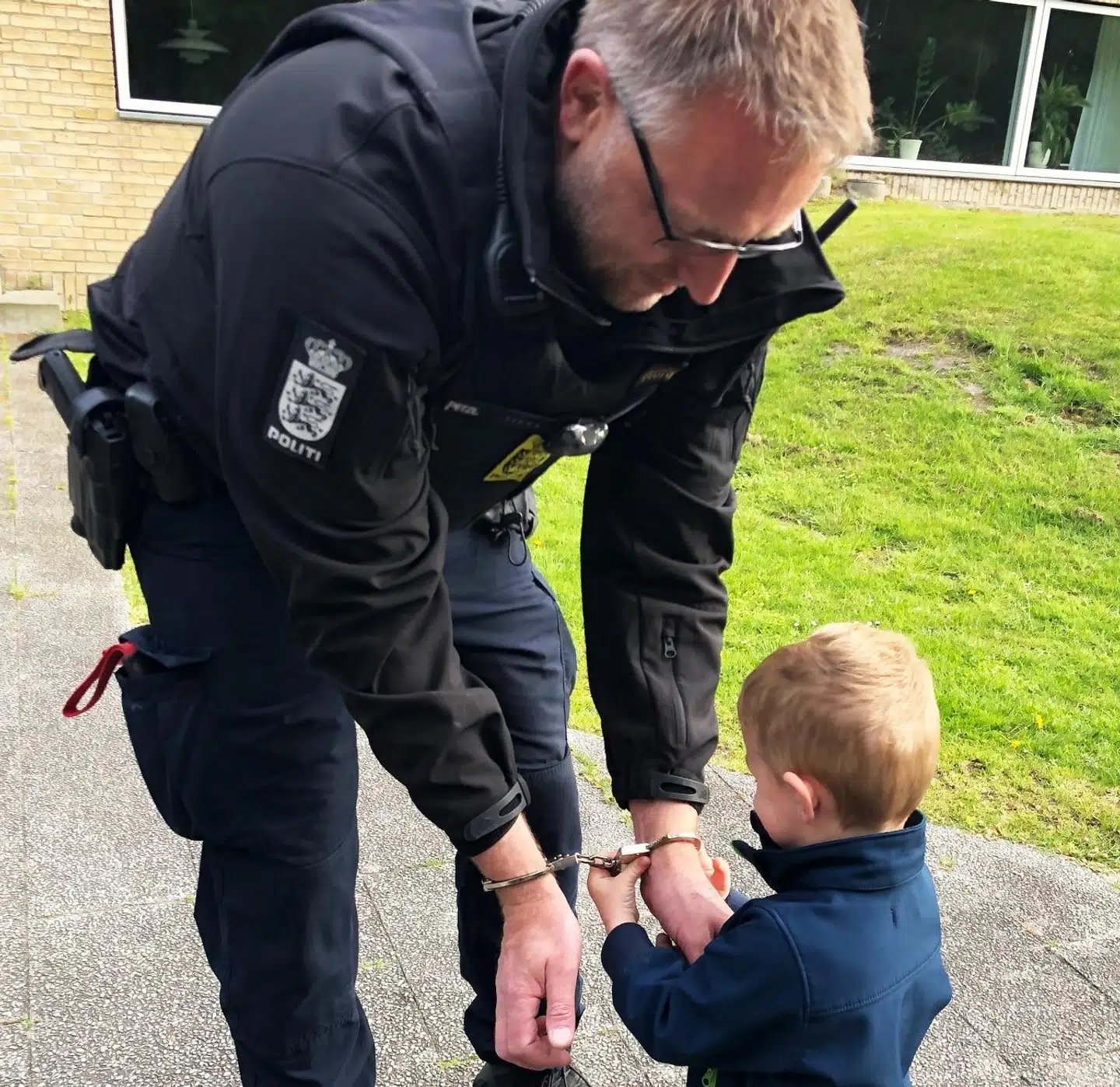 Her giver Noah en af politibetjentene håndjern på. Foto: Nordsjællands Politi