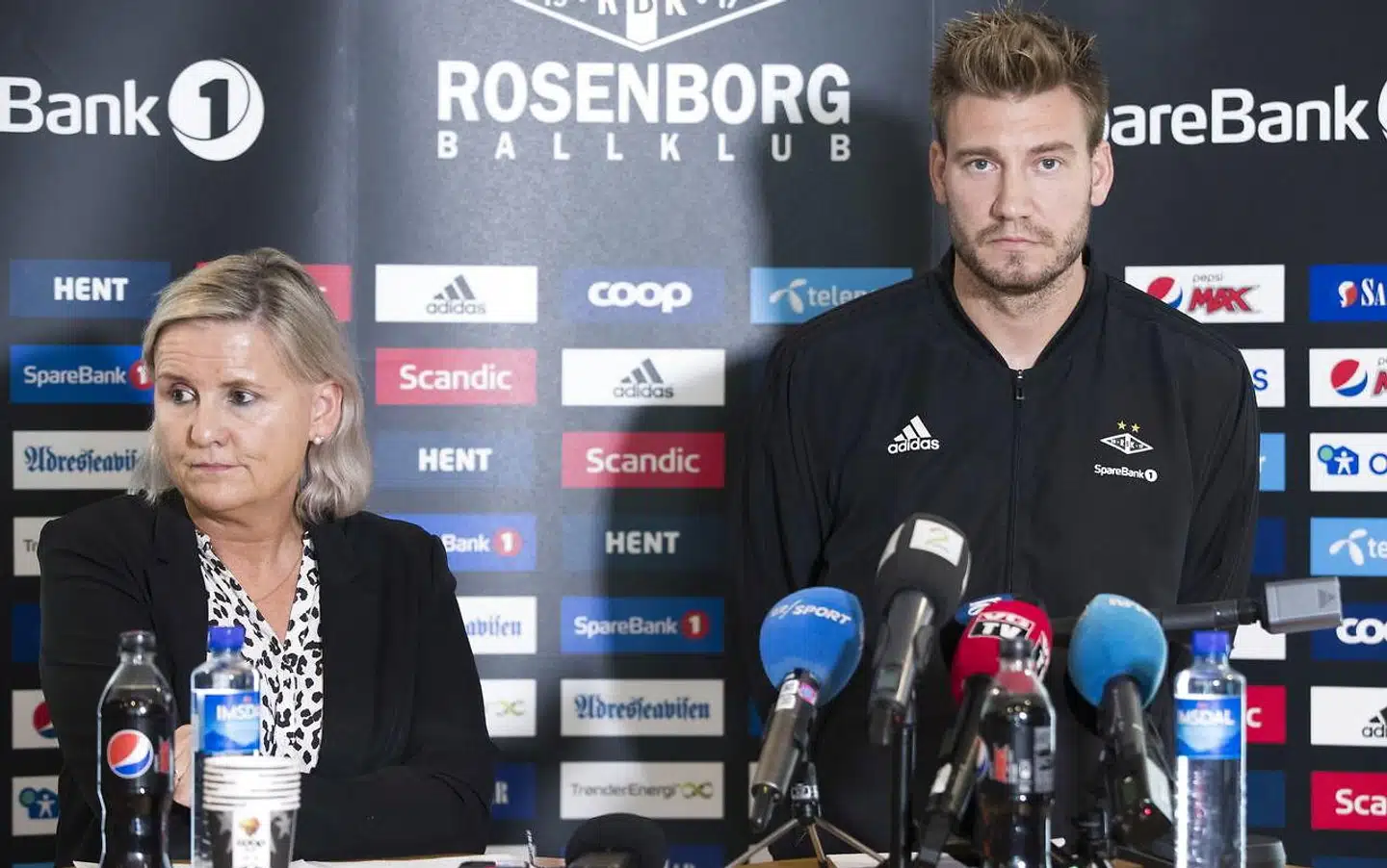 Den daglige leder i Rosenborg, Tove Moe Dyrhaug, måtte klare de mange, mange spørgsmål, der kom fra pressen. Imens stod Bendtner ved siden af med et tomt blik.